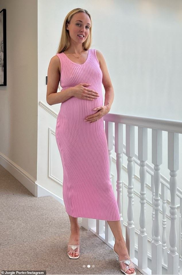 In the snap, the Hollyoaks star, 36, cradled her blossoming bump in a bright pink figure-hugging midi dress from PrettyLittleThing