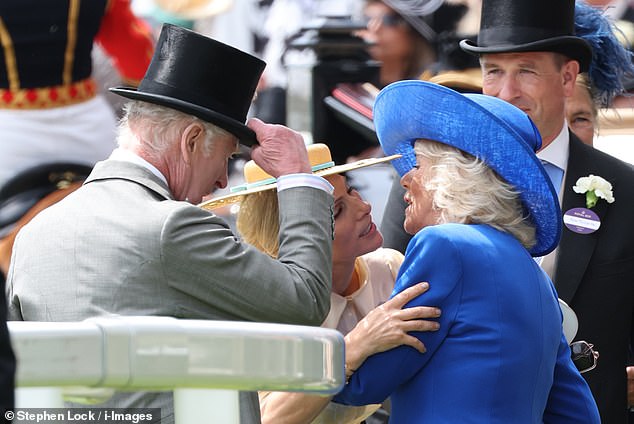 Zara struggles as she tries to kiss Camilla, who is wearing a large hat, on the cheek
