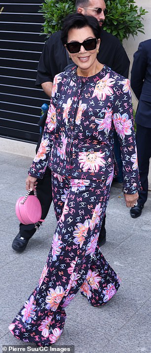 The 68-year-old momager stepped out in a navy blue jacket and matching wide-leg pants, featuring a Chanel logo and pink floral print