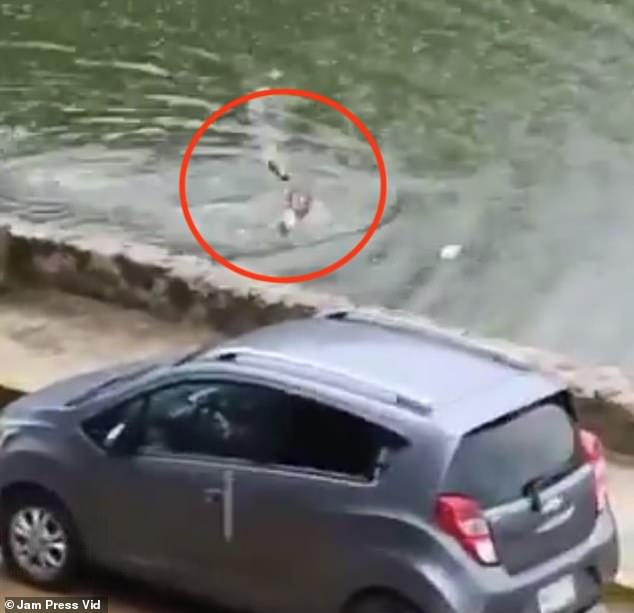 Before climbing out of the murky water, the man threw his shoes on land