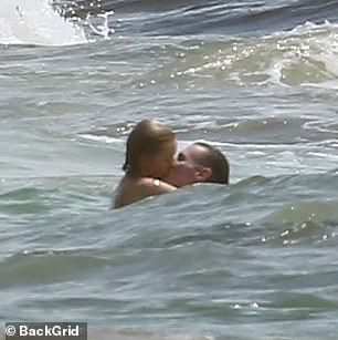 They couldn't keep their hands off each other as they hugged and kissed in the ocean