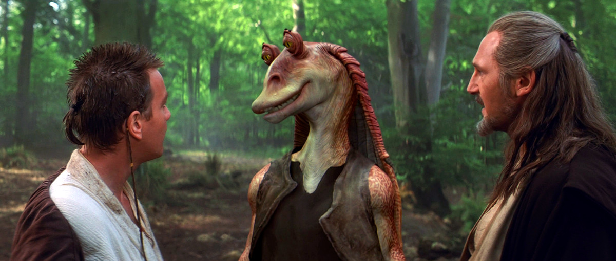 Jar Jar Binks stands and talks to Qui Gon and Obi Wan in Star Wars: Episode 1