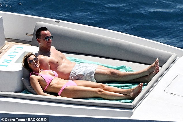 Lying next to her husband, Toni showed off her slim physique in a powder pink bikini as she made the most of the rising temperatures on the Italian coast.