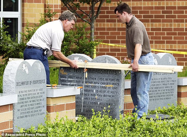 The Republican Party-authored legislation requires the display to be in “large, easy-to-read font” in all public classrooms, from preschools to state-funded universities.  Pictured: Workers remove a Ten Commandments monument at West Union High School, June 9, 2003, in West Union, Ohio