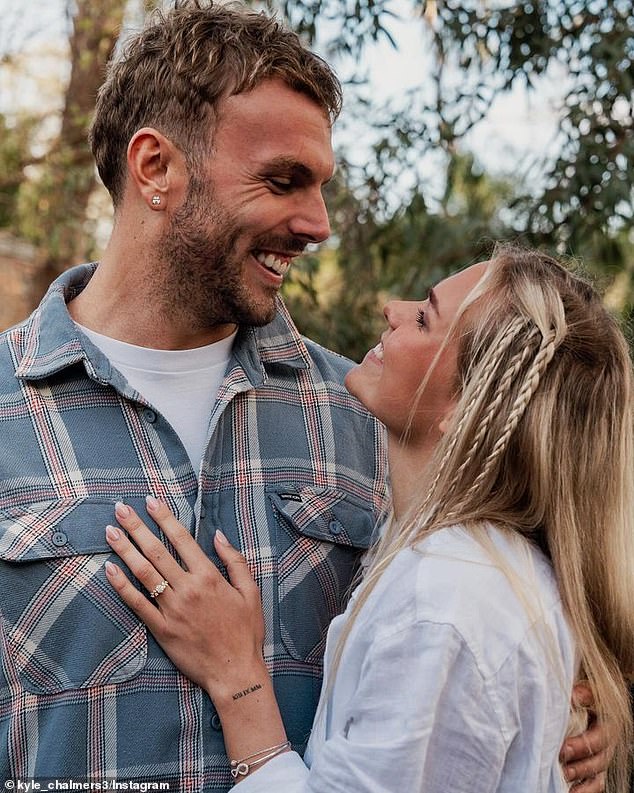 In the first image, Kyle can be seen beaming as his Norwegian lover tenderly places her hand on his muscular chest, giving fans a glimpse of her stunning engagement ring.