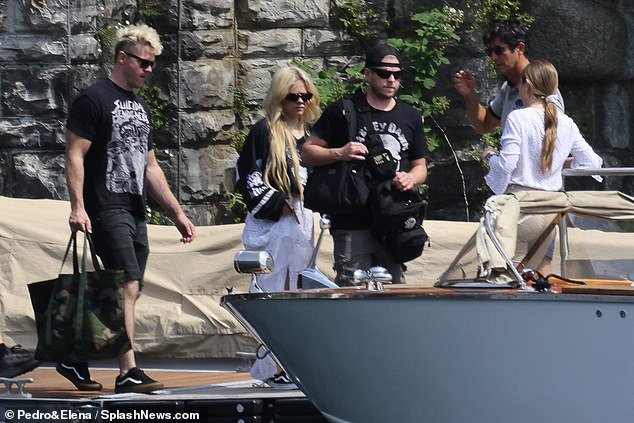 The lovebirds are pictured with their friend on the way to their boat