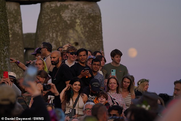 Celebrating the summer solstice at Stonehenge as the sun sets