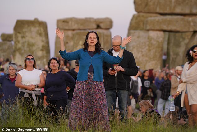 Revelers watch the sunset at Stonehenge on Thursday evening