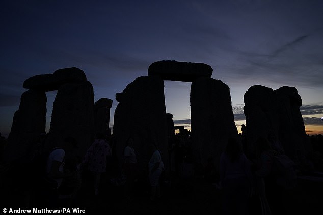 People gather at Stonehenge in Wiltshire at sunset