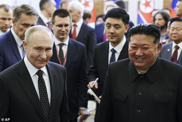 Russian President Vladimir Putin (left) and North Korean leader Kim Jong Un smile as they walk after talks in Pyongyang, North Korea, on Wednesday, June 19, 2024