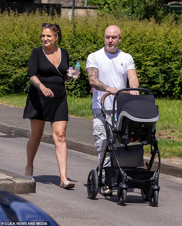 The actress, 37, looked stunning in a plunging black mini wrap dress as she strolled with boyfriend Anthony Huggins and their new bundle of joy on their way to register the child's birth