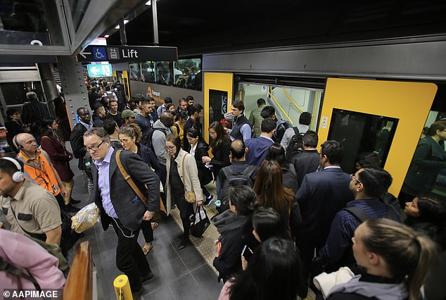 A record 547,300 migrants poured into Australia in 2023 - the highest ever in a calendar year (pictured are Sydney train commuters)