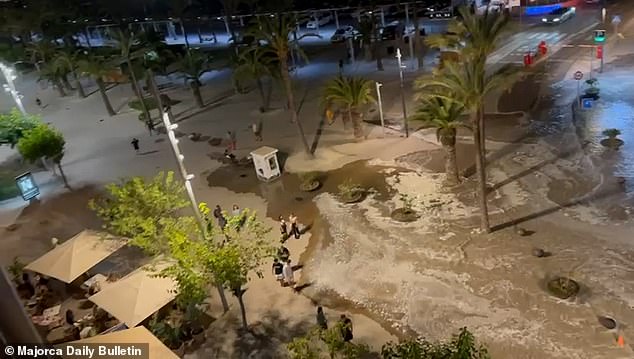 In a video of the moment the water poured over the road, people can be seen walking past the alarming flood