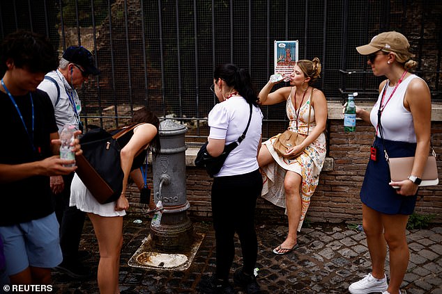 A woman fills her bottle with water at a drinking fountain near the Colosseum during a heat wave in Rome, Italy, June 20, 2024