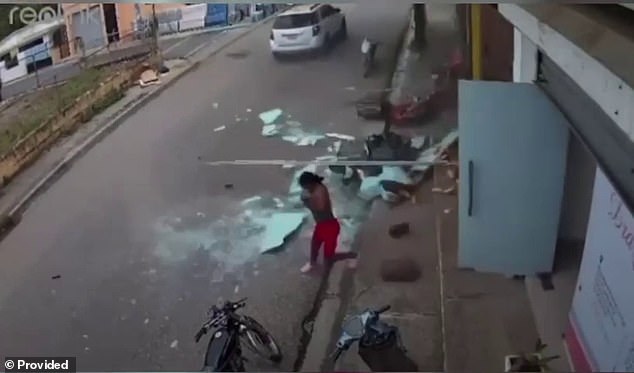 A woman runs into the street on Thursday after an oven exploded at a bakery in La Vega, Dominican Republic