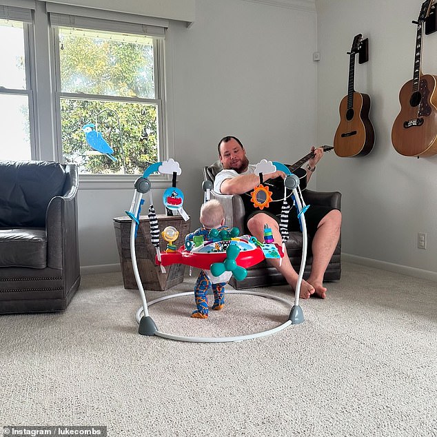 The father of two strums the guitar as his little one watches