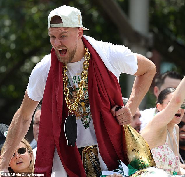 The injured Kristaps Porzingis wore a chain and a WWE championship belt during the parade