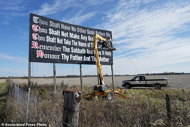 Louisiana law forces all classrooms to display the Ten Commandments.  Pictured: Workers repaint a Ten Commandments billboard on Interstate 71 on Election Day near Chenoweth, Ohio, Tuesday, November 7, 2023