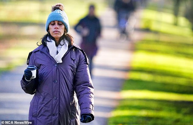 The Bureau of Meteorology says low pressure areas that have been along the Tasman Sea all week will continue to bring cool, southerly winds along Australia's lower east coast on Saturday.  It depicts a woman dressed robustly for the cold weather
