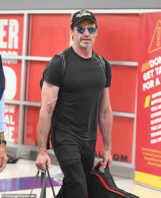 The Wolverine star looked great in a form-fitting T-shirt that showed off his sculpted pecs and massive biceps.  (Pictured)