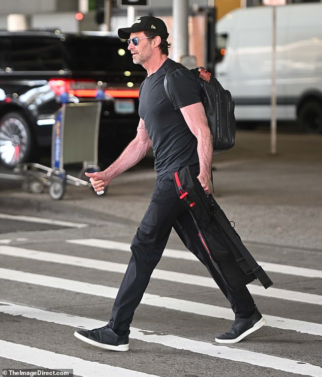 He completed his look with matching black trousers, a baseball cap, dark aviator sunglasses and a pair of black runners with white trim.