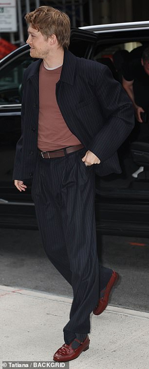 His two-piece suit consisted of a casual jacket with padded shoulders and high-waisted trousers with a brown belt