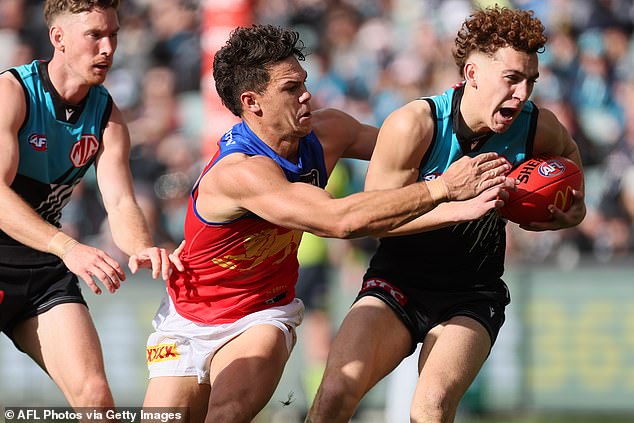 Cameron Rayner, pictured tackling Port Adelaide's Logan Evans, was handed a gift goal by the referee's decision to award a 50-metre penalty for the Willem Drew incident