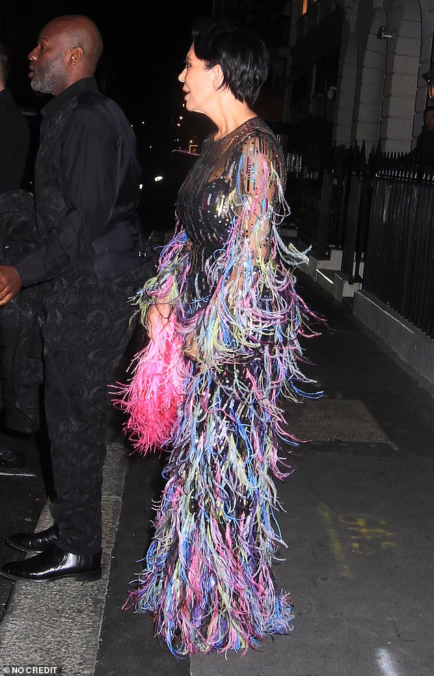 Her dress was covered in feathers and lines of sequins in all different colors, and she carried a fluffy pink bag.