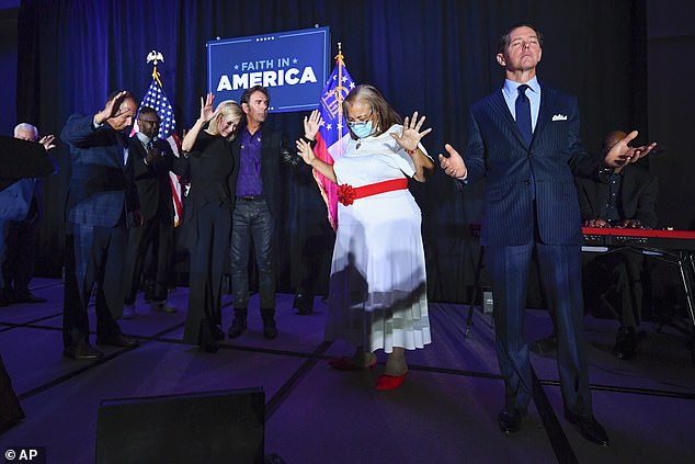 Ralph Reed, from right, Dr. Alveda King, Journey keyboardist Jonathan Cain and the president's personal minister Paula White Cain, and others pray on stage during a Donald Trump campaign event