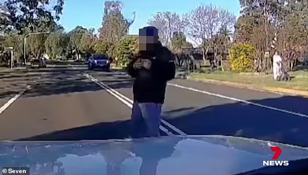 A man then started filming the woman who had lain under the front of the car