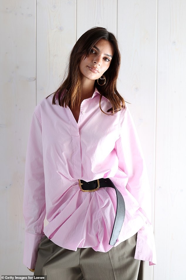 Wearing an oversized pink shirt and dramatic wide leg trousers, Emily channeled business chic