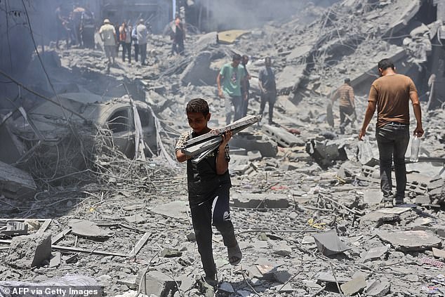 A boy carries items from the rubble of a building destroyed by Hamas militants in the Gaza City refugee camp.  Israel claimed it had targeted two 