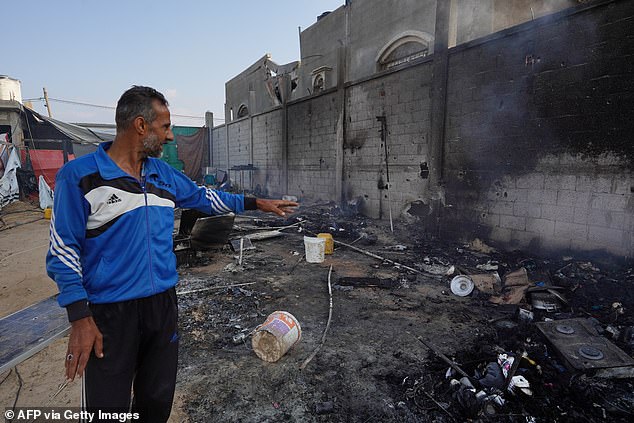 A Palestinian man points to ash in a tent area the day after an attack on the al-Mawasi area, northwest of the Palestinian city of Rafah on June 22, 2024