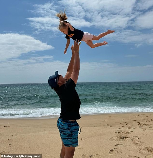 In another photo, Mahomes lovingly tossed his daughter in the air as they stood on the beach