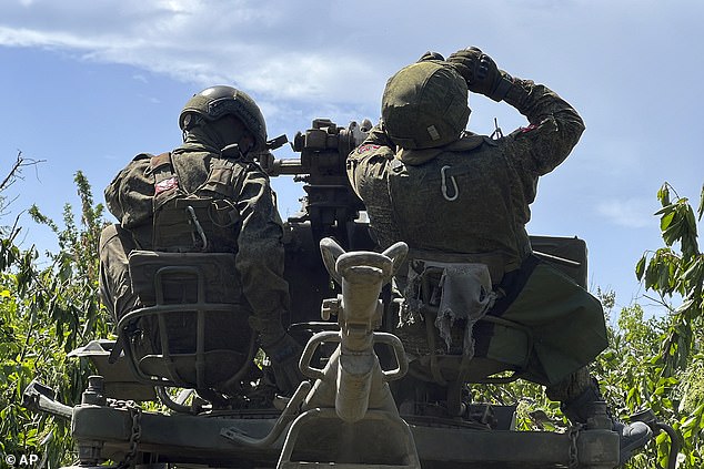 In this photo released by the press service of the Russian Ministry of Defense, Friday, June 21, 2024, Russian soldiers operate an anti-aircraft gun at a secret location in Ukraine