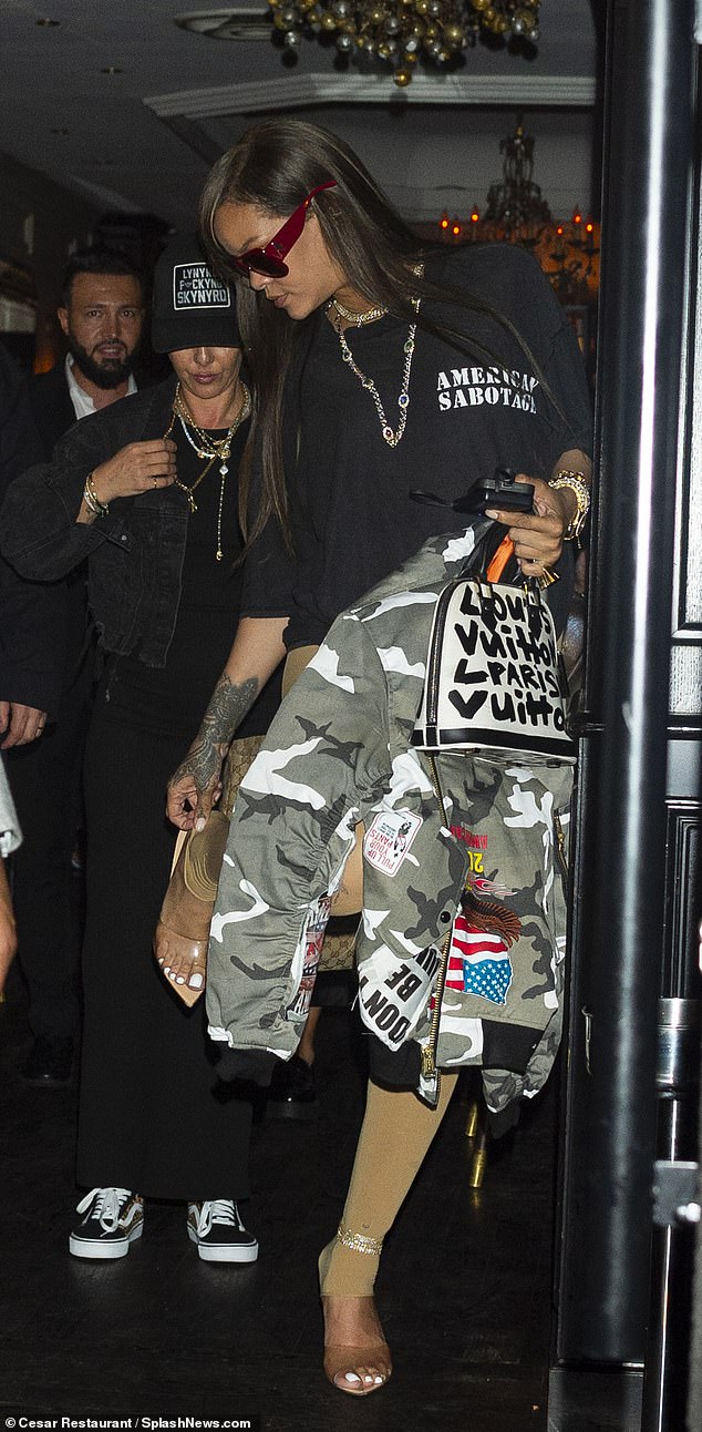 Rihanna continued to amp up her edgy look with a camoflauge bomber jacket with a distressed American flag on the back