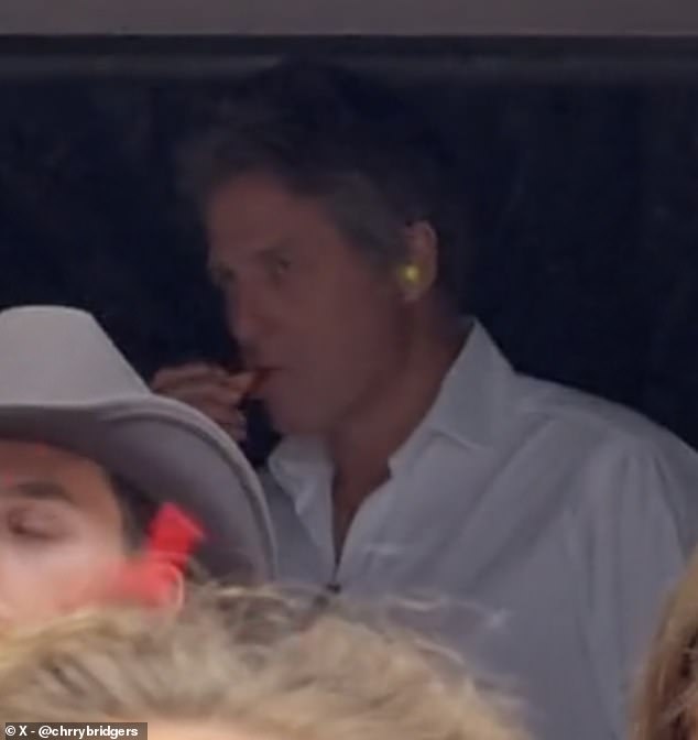 Actor Hugh Grant eats carrots during the Eras Tour at Wembley on Friday evening as he stands in the VIP tent among a host of A-listers