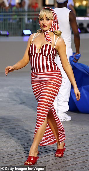 Sabrina Carpenter, 25, looked right at home on the catwalk as she stunned in a red and white striped Jacquemus ensemble and matching headscarf