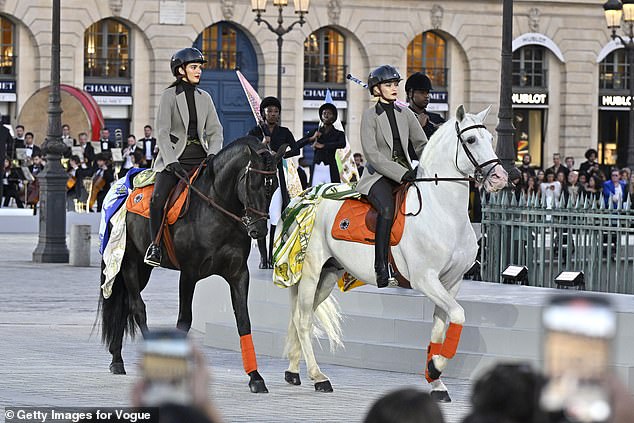In keeping with the sports theme, the two models cruised around Place Vendôme in matching taupe blazers with shiny black collars