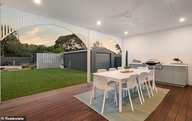 There is also an outdoor dining area with a built-in grill that overlooks the backyard