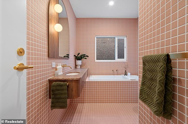 The master bathroom is particularly striking with pink floor-to-ceiling tiles, a curved shower alcove and a spacious bath