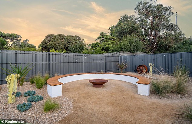 The rear garden consists of a modern fireplace with a curved sofa
