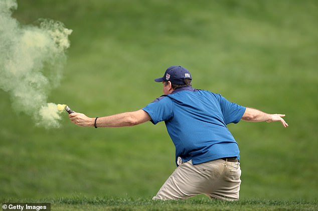 The fairway invaders, who appeared to wear messages about climate change on their T-shirts, threw red, white and yellow powder at the golf course