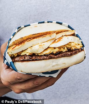 A gigantic breakfast sandwich with cevapi and scrambled eggs