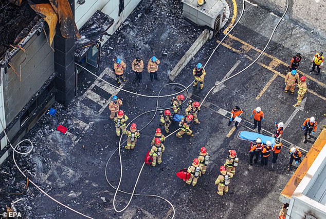 Firefighters retrieve the bodies of workers from the site after finally bringing the fire under control