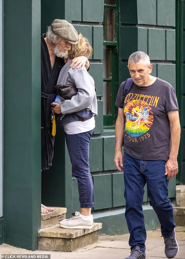 Sir Ian McKellen hugs the friend outside his London home yesterday after his accident