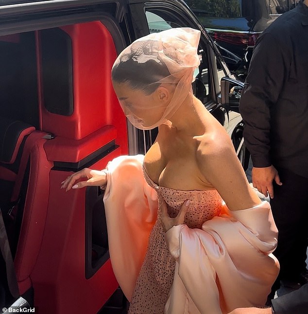 Kylie struggled to control her ample cleavage in the strapless dress as she walked into the car