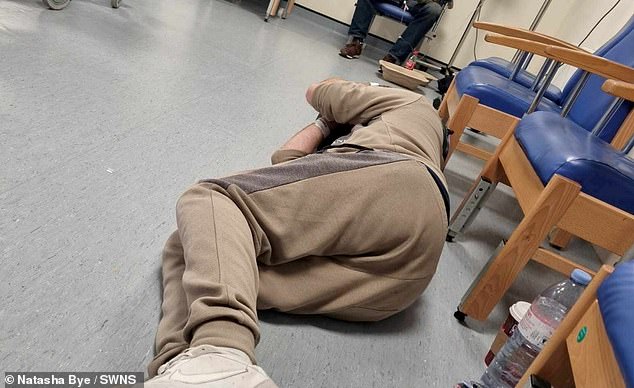 Pictured: A man sleeps on the floor in A&E as he waited 45 hours for a bed at William Harvey Hospital in Ashford, Kent