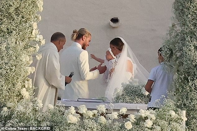 The couple exchanged their vows while surrounded by masses of beautiful white flowers