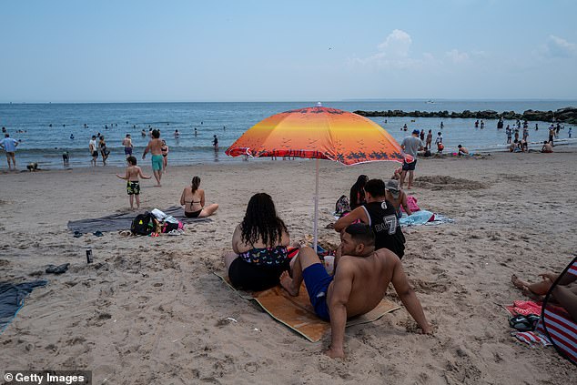 People visit Coney Island beach on a sweltering afternoon on the first weekend of summer on June 22